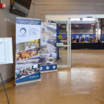 Entrance display for a CCPPA Inspector Information Session featuring signage, banners, and resource tables welcoming attendees to a technical seminar on concrete pipe and precast structures.